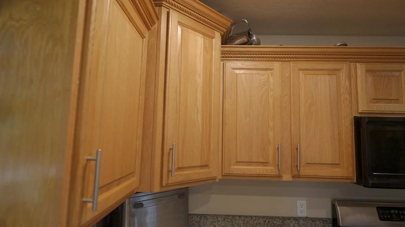 Close-up of honey oak upper cabinets before refinishing