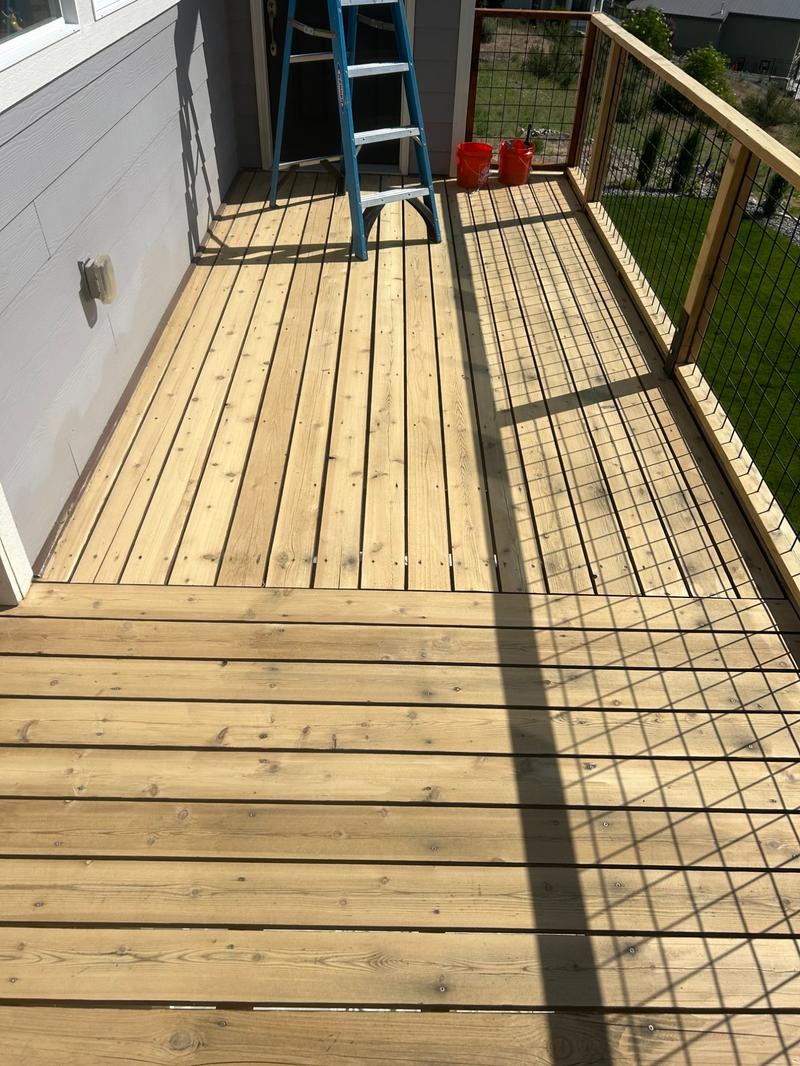 New raw bare lumber deck section along house side before staining
