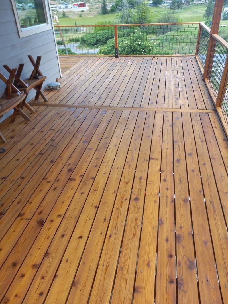 Same deck after staining with rich warm golden amber finish and outdoor furniture
