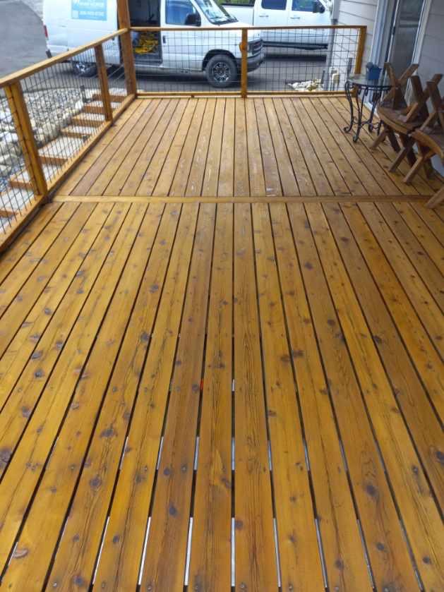 Deck section after staining with rich warm golden finish along house side