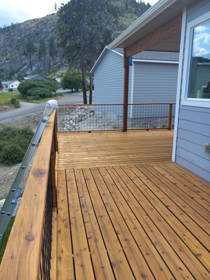 Completed deck staining viewed from elevated angle showing rich warm finish