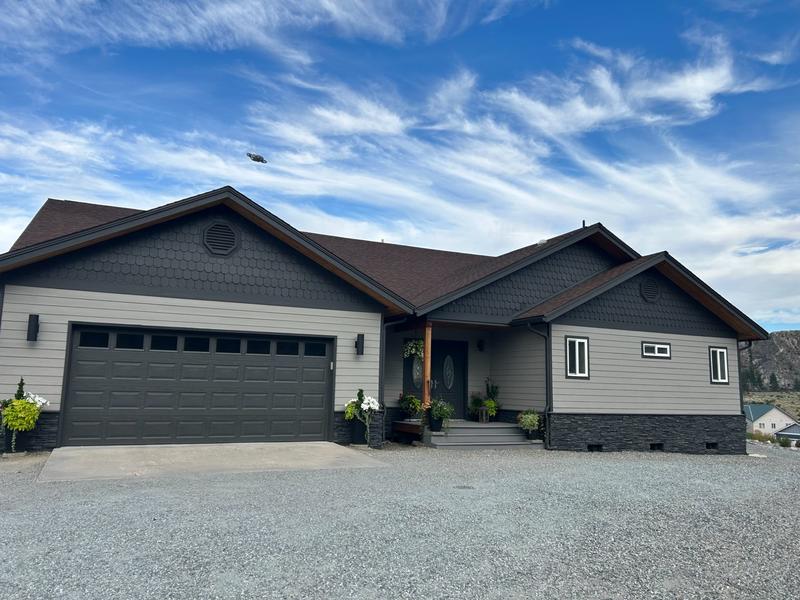 Completed exterior painting project showing dark charcoal home