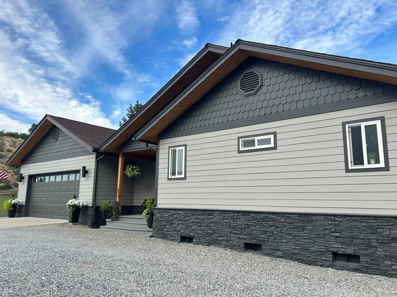 Close-up of front entry showing dark gray siding with scalloped shingle gable detail