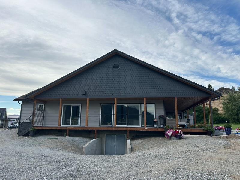 Rear view of house after painting in dark charcoal with natural wood porch posts