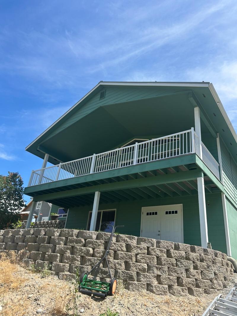 Rear two-story view after repainting in green teal with white balcony railing