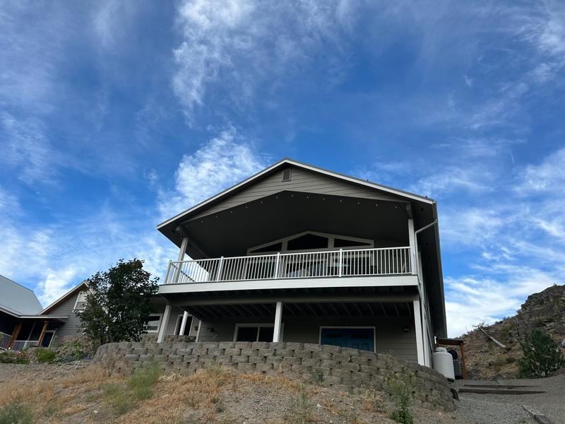 Rear two-story view of house with dark gray siding before repainting