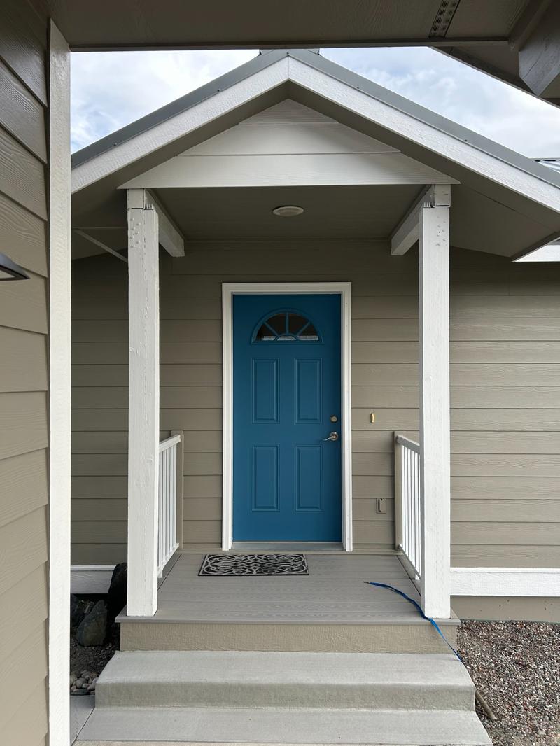Front entry porch with teal blue front door and white trim columns