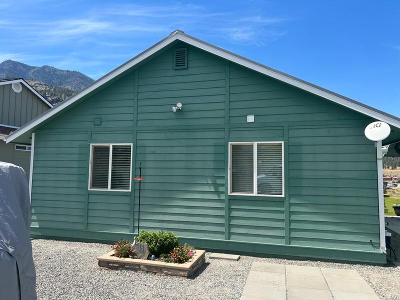 Side of house after repainting in bold green teal color with white trim